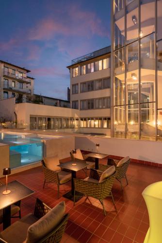a patio with tables and chairs next to a building at iQ Hotel Firenze in Florence