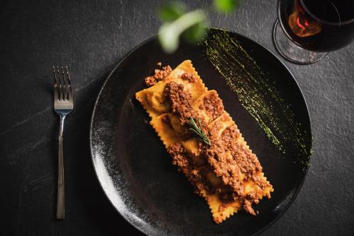 a piece of cake on a black plate with a fork at iQ Hotel Firenze in Florence