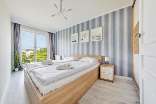 sypialnia z dużym łóżkiem i oknem w obiekcie Apartamenty Sun & Snow Residence I Jastrzębia Góra w Jastrzębiej Górze