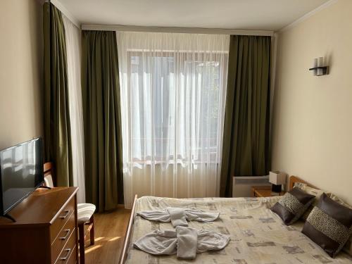 a hotel room with a bed and a television at 2 bedroom apartment near Gondola in Bansko