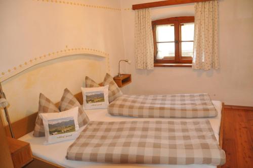 a bedroom with two beds and a window at Ferienwohnung Schuster am Fellerer in Aschau im Chiemgau