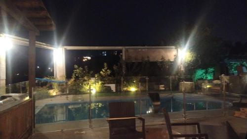 a view of a swimming pool at night at Evergreen studios in ‘Isfiyā