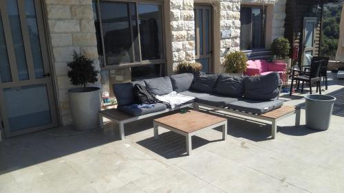 a couch and a coffee table on a patio at Evergreen studios in ‘Isfiyā