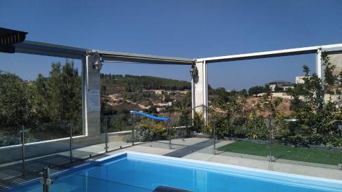 a swimming pool with a view of a house at Evergreen studios in ‘Isfiyā