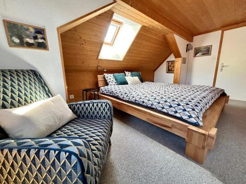 um quarto com uma cama e um sofá num quarto em Wunderschöne Maisonette-Ferienwohnung in stattlichem Toggenburgerhaus em Sankt Peterzell