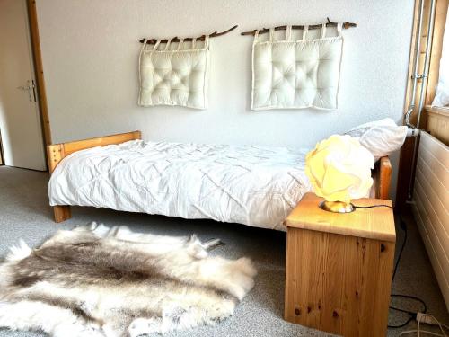 1 dormitorio con cama y alfombra peluda en Wunderschöne Maisonette-Ferienwohnung in stattlichem Toggenburgerhaus en Sankt Peterzell