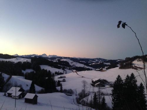 a kite flying in the sky over a snow covered mountain at Wunderschöne Maisonette-Ferienwohnung in stattlichem Toggenburgerhaus in Sankt Peterzell