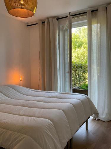 a bedroom with a large bed and a window at Le Safran in Obernai