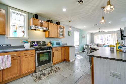 a kitchen with wooden cabinets and a counter top at The 1818 Home with Porch and Grill - 1 Mi to Beach! in Lake Como