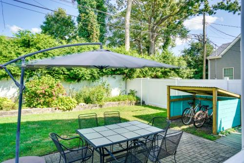 a table and chairs under an umbrella in a yard at The 1818 Home with Porch and Grill - 1 Mi to Beach! in Lake Como