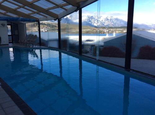 a swimming pool with a view of a mountain at Spinnaker Bay Apartments in Queenstown