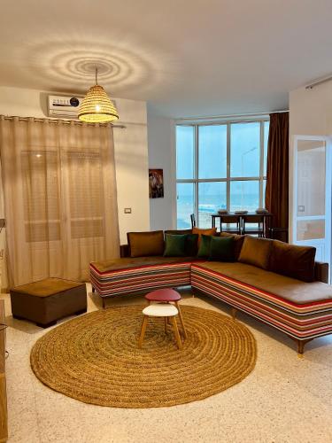 ein Wohnzimmer mit einem Sofa und einem Tisch in der Unterkunft Appartement Vue de Mer Pied dans l'eau in Tacape