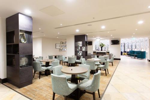 a waiting area with tables and chairs in a building at DoubleTree by Hilton Hotel Nottingham - Gateway in Nottingham
