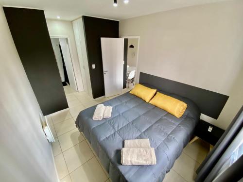 a bedroom with a blue bed with yellow pillows at Hermoso departamento Godoy Cruz in Godoy Cruz