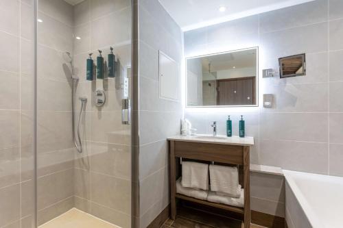 a bathroom with a shower and a sink and a mirror at DoubleTree by Hilton Hotel Nottingham - Gateway in Nottingham