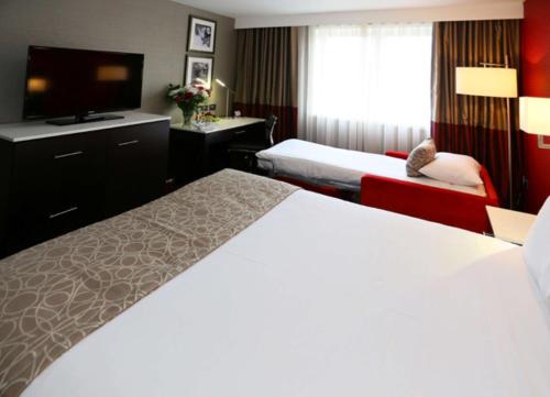 a hotel room with two beds and a flat screen tv at DoubleTree by Hilton Hotel Nottingham - Gateway in Nottingham