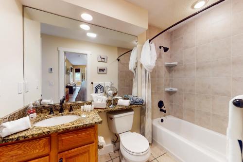 a bathroom with a toilet and a sink and a tub at Downhill Delight in Lake Harmony