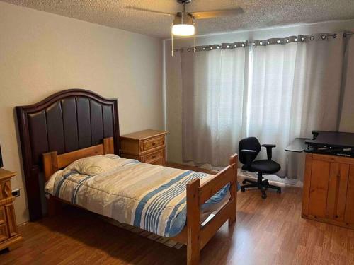 Schlafzimmer mit einem Bett, einem Schreibtisch und einem Stuhl in der Unterkunft Casa completa de 3 cuartos en una zona tranquila. in Ciudad Juárez