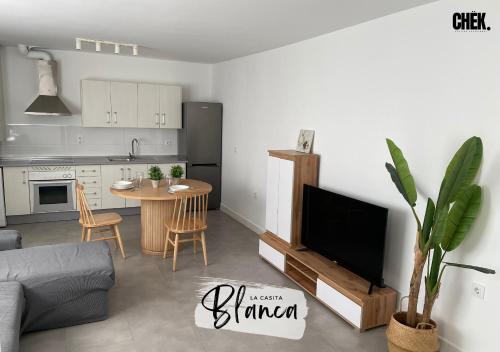 uma sala de estar com uma cozinha e uma mesa com uma televisão em LA CASITA BLANCA by chëk em Jaén