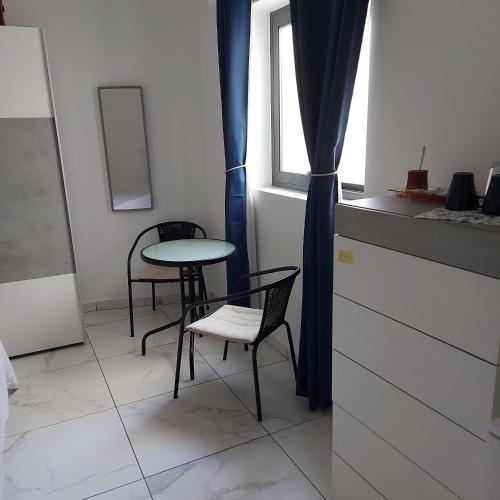 a table and chairs in a room with a window at CASA GRIMA - private double room in Birkirkara