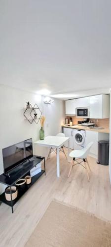 un salon avec une table et une cuisine dans l'établissement Studio Rochereau Climatisé - Metro - Gare - Wifi, à Toulouse