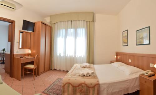 a bedroom with a bed and a desk and a window at Residence Piccola Oasi in Vigonza