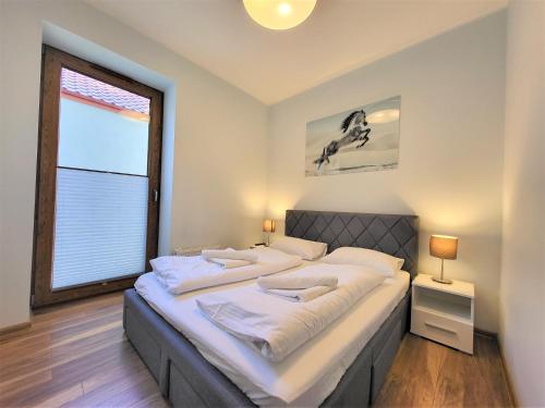 a large bed in a room with a large window at Apartament Bryza Aquarius - z miejscem parkingowym in Ustka