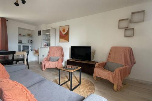 sala de estar con sofá, sillas y TV en Gîte NO 9, en Neufchâteau