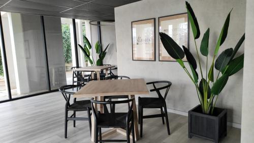 una sala da pranzo con tavoli, sedie e una pianta in vaso di Apartamento Greta Río CalleCalle a Valdivia