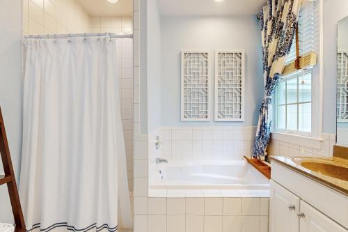 a bathroom with a tub and a shower curtain at Bear Trap Dunes --- 34 Sycamore Street in Ocean View