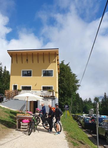 un groupe de personnes debout devant un bâtiment dans l'établissement Chalet Jaune PINEA, à Sarcenas