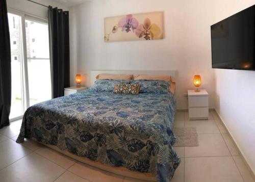 een slaapkamer met een bed en een flatscreen-tv bij Estrella Dominicus con hermosa piscina! in La Laguna