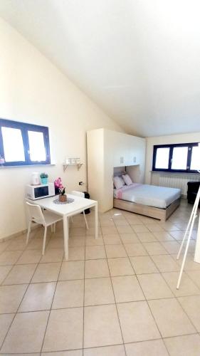 a bedroom with a bed and a desk and a table at Monolocale Azzurra in Magione