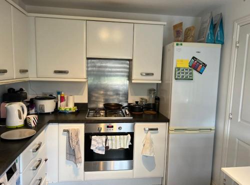 una cocina con estufa y refrigerador en Salimi, en Bridgend