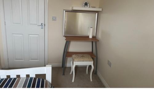 a dressing room with a mirror and a stool at Salimi in Bridgend