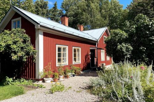 a red house with plants in front of it at Spacious house near water and nature in Odensbacken