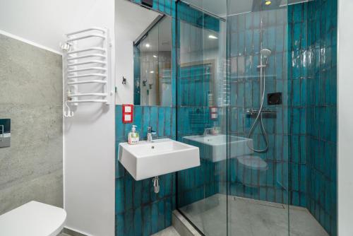 a bathroom with a sink and a glass shower at Kaszuby, dom kaszubski nad jeziorem Danielowa Dolina in Szymbark