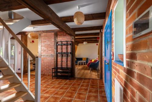 a room with a staircase and a brick wall at Kaszuby, dom kaszubski nad jeziorem Danielowa Dolina in Szymbark