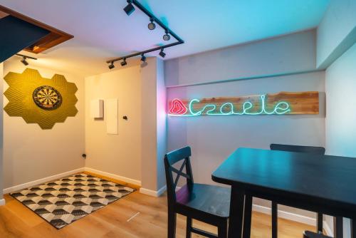 a dining room with a table and a neon sign at Kaszuby, dom kaszubski nad jeziorem Danielowa Dolina in Szymbark