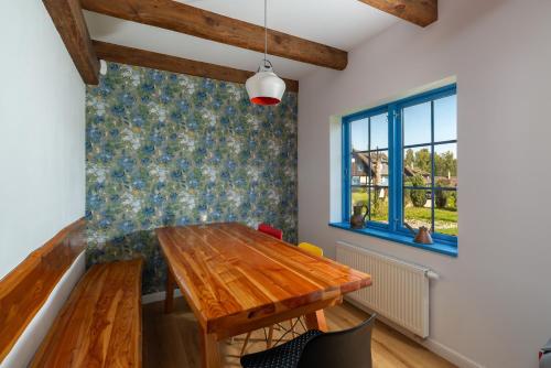 a dining room with a wooden table and a window at Kaszuby, dom kaszubski nad jeziorem Danielowa Dolina in Szymbark