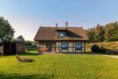 a small house with a large grassy yard at Kaszuby, dom kaszubski nad jeziorem Danielowa Dolina in Szymbark