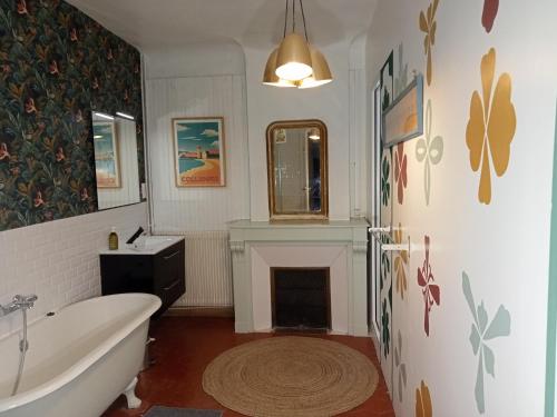 łazienka z białą wanną i kominkiem w obiekcie Le Mas Palegry Chambres d'hôtes Perpignan w Perpignanie