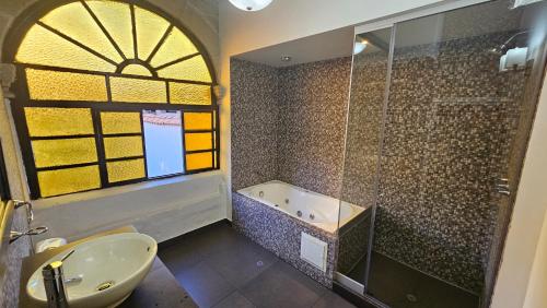 a bathroom with a shower and a sink and a tub at La Llave 351 in Cusco