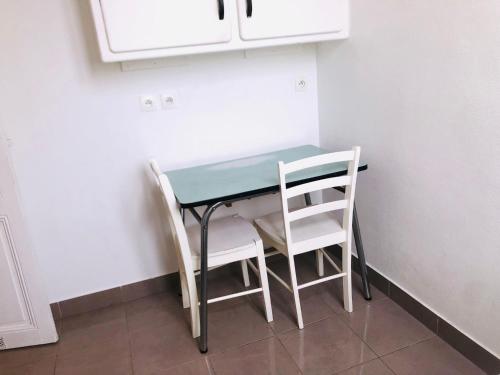 stół i dwa krzesła w małym pokoju w obiekcie Bellicime w Paryżu