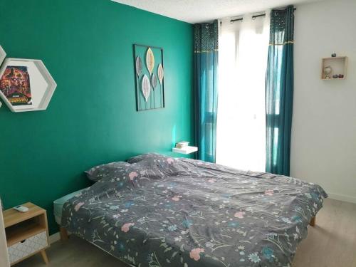 a bedroom with a bed and a blue wall at Au petit Bonheur, centre St-Raphaël, 8min à pied plage in Saint-Raphaël
