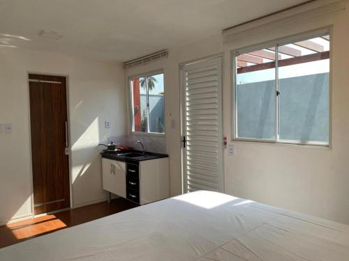 a bedroom with a bed and a sink and a window at Bangalô Miraflores in Chapada dos Guimarães