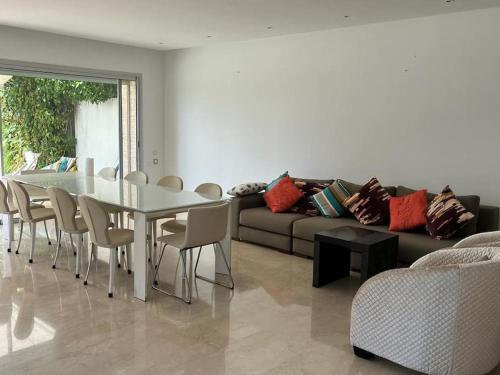 a living room with a table and a couch at Belle Villa à Bouznika plage - Golf Bouzbay in Bouznika