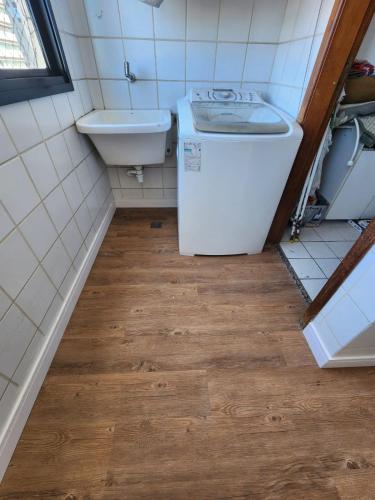 a small bathroom with a sink and a washing machine at Apartamento Enseada do Suá in Vitória