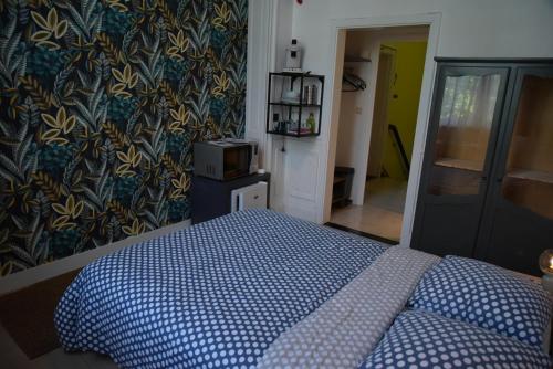 um quarto com uma cama com um edredão azul em Le Piercot em Liège