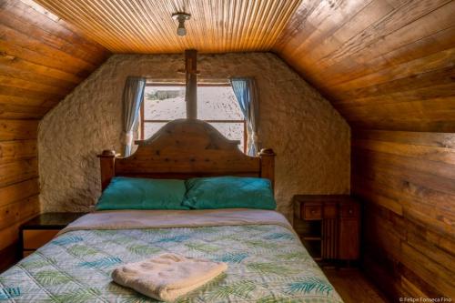ein Schlafzimmer mit einem Bett in einer Holzhütte in der Unterkunft Cabaña Campestre La Esperanza in Duitama